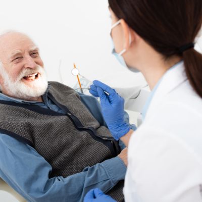 Smiling senior man having teeth treatment by dentist